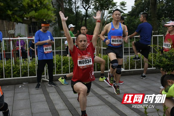 开跑前，参赛选手们正在认真地热身。