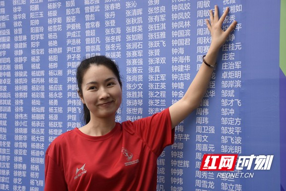 比赛结束后，一位女参赛选手站在“英雄榜”合影墙前，手指放在自己的名字上，希望用照片定格这一刻的美好记忆。