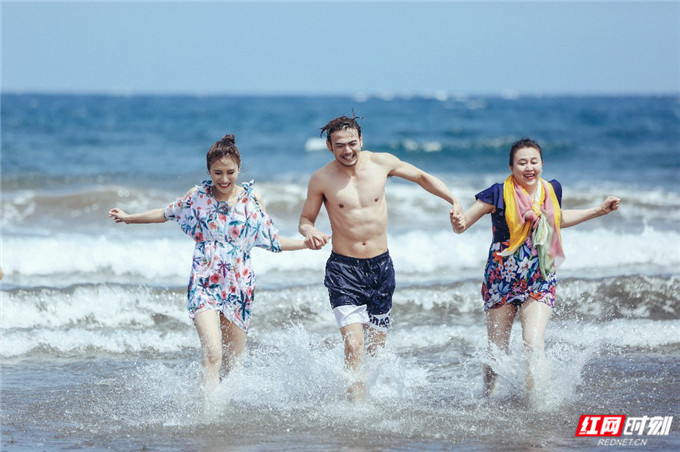 玩到兴起，杨烁还牵起妈妈、妻子兴奋地朝海边奔跑。