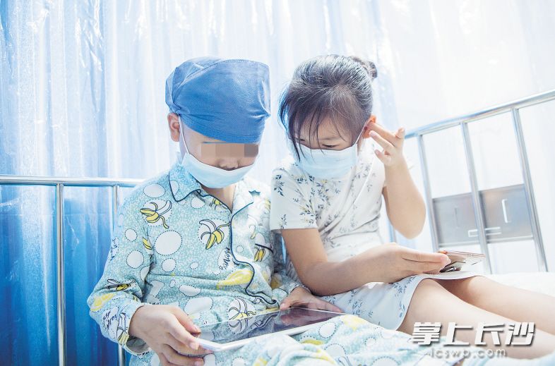 　　兄妹俩挤在一起玩游戏。 　　长沙晚报通讯员 申勇 摄