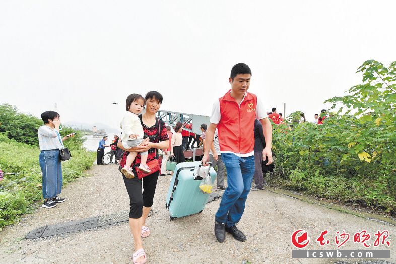 　　←一位志愿者帮助兴马洲上的居民搬运行李。均为长沙晚报全媒体记者 邹麟 余劭劼 摄影报道