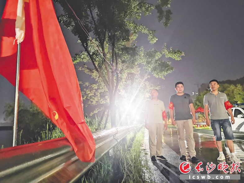 　　11日晚11时许，开福区秀峰街道工作人员冒雨巡查江堤。长沙晚报全媒体记者 小刘军  摄