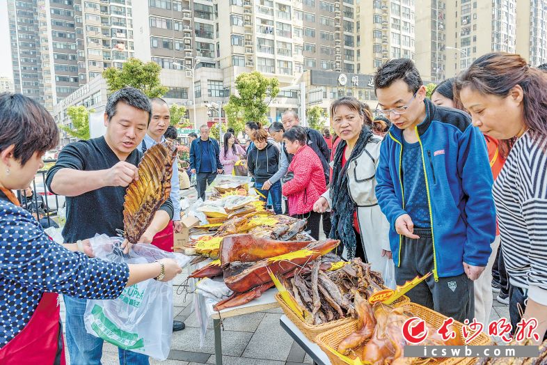 　　↑在新开铺街道豹子岭社区，居民们大袋小袋地购买各种龙山土特产，以消费助力老乡脱贫。均为长沙晚报全媒体记者陈飞摄