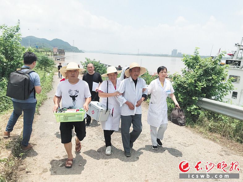 　　颜新艳（背药箱者）在兴马洲。长沙晚报全媒体记者 卜劲文 通讯员 符凤姣 李咨 摄影报道