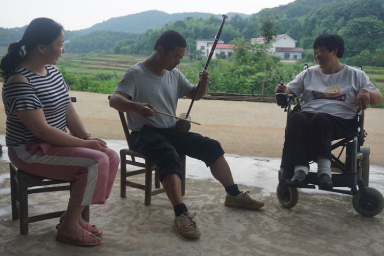 6月12日，农忙之余，许志礼拉二胡给爱人和女儿听。图片由岳麓区融媒体中心提供