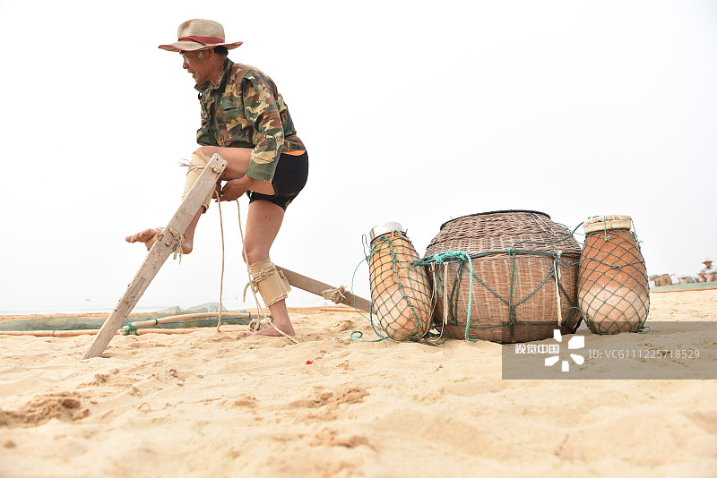 山东省日照海滨国家森林公园内的海边，高跷绑上双腿，渔网打开，背上虾蒌，这一切收拾妥当之后，就可以下海了作业了。