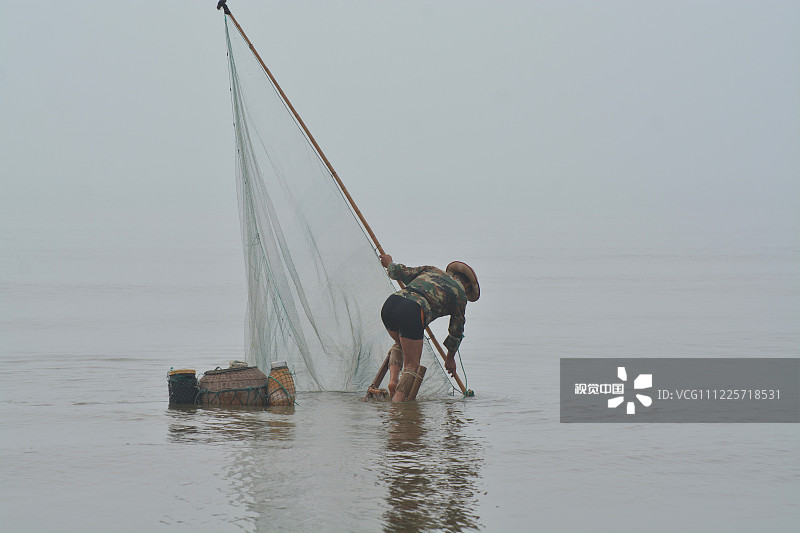 山东省日照海滨国家森林公园内的海边，郭长海用渔网竹竿做支撑，站上了高跷。