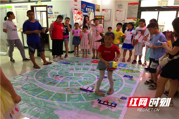 孩子们在垃圾分类飞行棋上做游戏，更加全面了解垃圾分类。.jpg