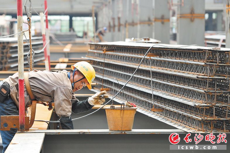 　　▲烈日下，黄花综保区进出口商品展示交易中心项目的工人正在施工。 