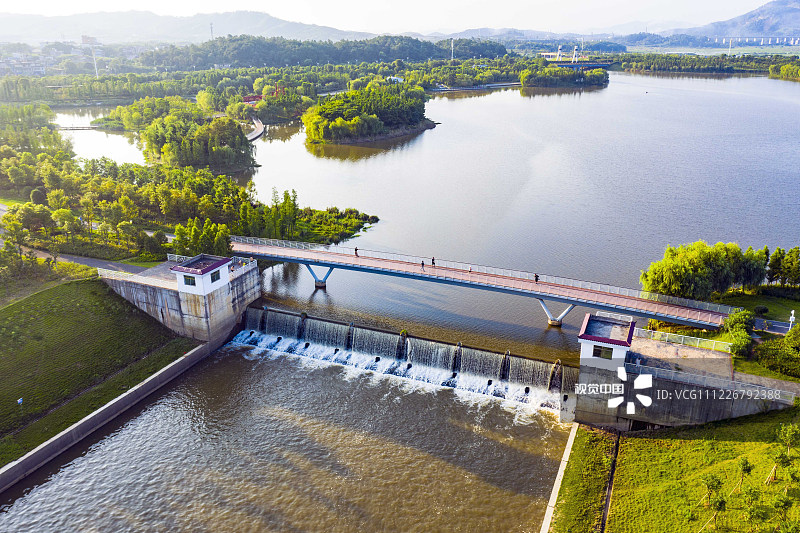 2019年7月23日，市民正在江西吉安新干县城市湿地生态区拦水坝人行钢桥上跑步健身。