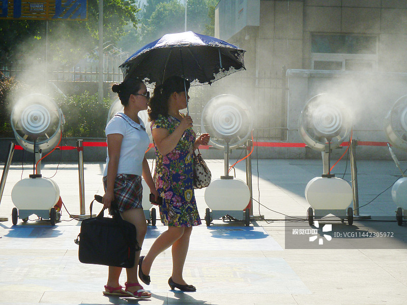 2013年07月29日，南京市珠江路，一商家在门前摆出一溜喷雾降温机为行人送清凉。