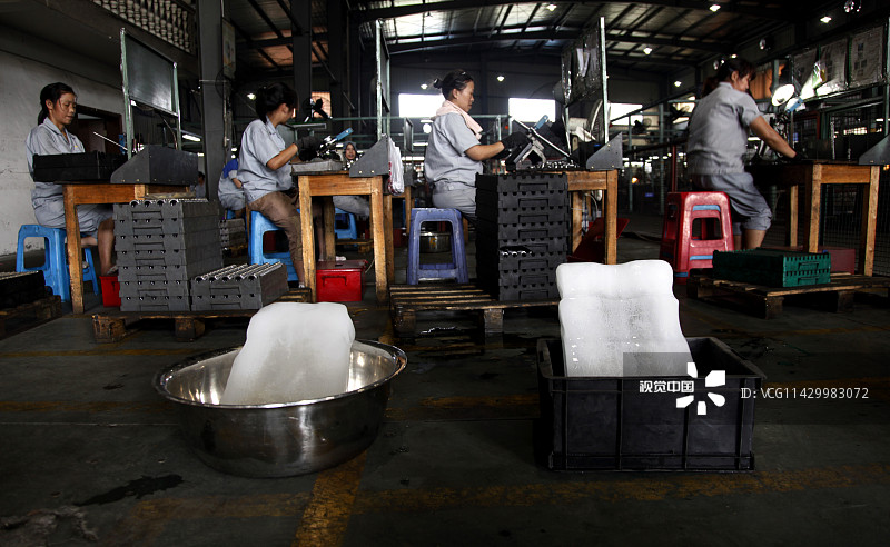 2012年07月16日，浙江省衢州市一家企业的厂房内，用冰块为一线工人降温。