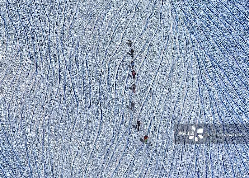 2016年7月19日讯（具体拍摄时间不详），受够了高温酷暑，一群登山者出发攀登法国夏蒙尼的阿尔卑斯冰川来“降降温”。摄影师Ignacio Palacios捕捉下了广袤的冰雪世界，和一队登山者坚定前进的场景。