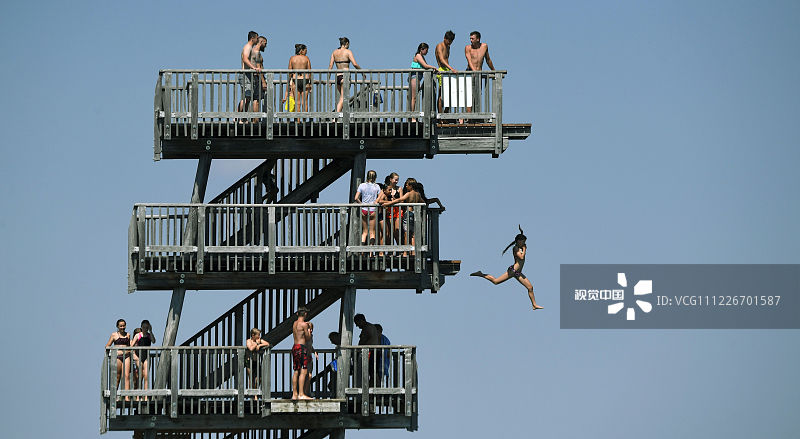 当地时间2019年7月24日，德国巴伐利亚州，当地迎来夏季高温天气。当地民众在湖边玩跳水。