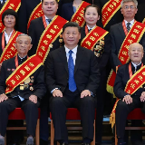 合影时，他们坐在了总书记身边