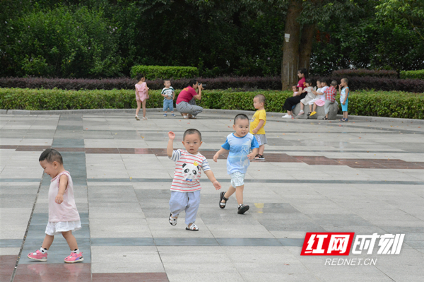 热浪散去，孩子们在广场上嬉戏。