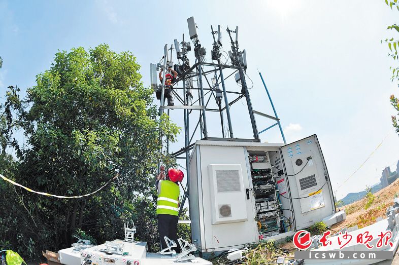 　　施工队员忙着安装5G无线信号设备。