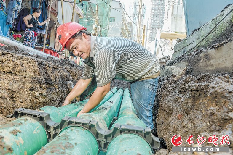 　　工人师傅正在沟里满头大汗地进行强电管改造。长沙晚报全媒体记者 陈飞 摄