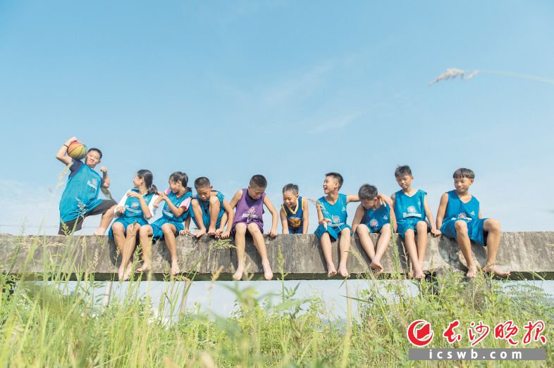 　　→高强度的体能训练结束后，队员们坐在公路旁的水渠上纳凉休息。这支乡村小学篮球队的小伙伴们通过努力，取得了8月12日参加“姚基金希望小学篮球季”全国集训及决赛的资格。