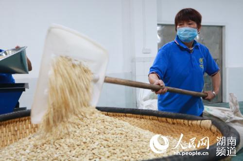 工人正在将过筛后的黄杏仁铲出