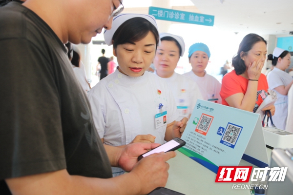 长沙市第一人民医院门诊办龙利亚为患者介绍电子健康卡注册方法.JPG