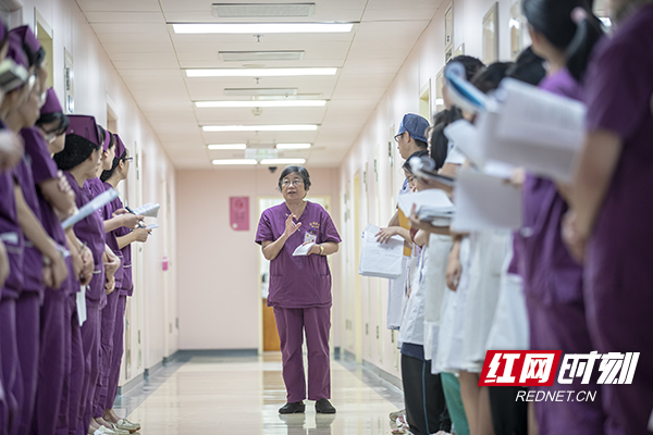 1.8月12日，湘雅医院，早上七点三十分。第一次见到岳少杰教授，她站在人群中听取医生、护士的介绍交接班情况，并且拿笔在小本子上进行登记病人情况。摄影 陈杰 .jpg