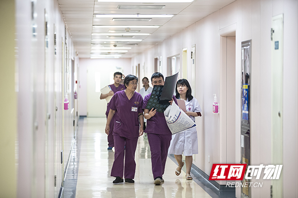 3.8月12日，湘雅医院，走廊里一位医生把一个新生儿的ct片子拿给岳少杰看，很多细节的画面必须要借助外界设备进行更详细的检查。摄影 陈杰.jpg