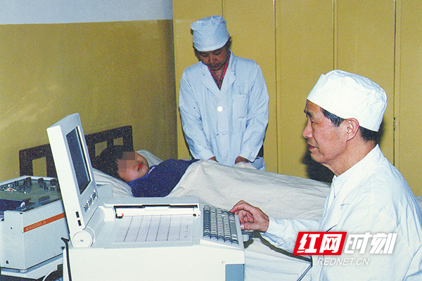 上世纪80 年代，湘雅二医院谢振武教授（右一）为患儿做心功能检查。（图片来源：湖南省卫生健康委宣传处）