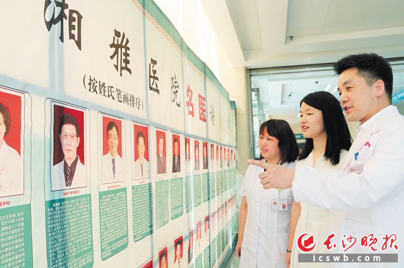 在“湘雅名医谱”前，郭峰和高清平给17岁的女儿郭乐之讲名医故事，勉励她好好学医。 长沙晚报通讯员 罗闻 摄