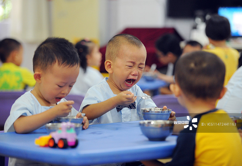 2015年9月1日，广东东莞，东城区创思东泰幼儿园小班课室。一名第一天上学的男孩，一边吃早餐一边大哭着要爷爷。