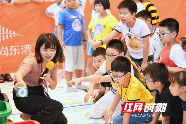 裁判小姐姐耐心地讲解每组小朋友投错的垃圾模型应该放在哪个垃圾桶。