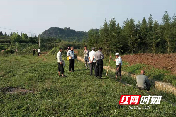 郑泽民在田间地头了解村情。.jpg