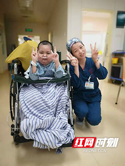 18 历时三个月的治疗，小朋友和医护人员已经建立了深厚的感情，在出院前与关心自己的医护人员合影。 张磊 摄.jpg
