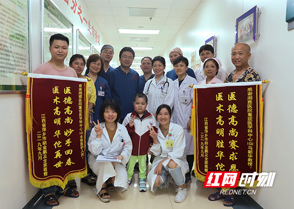 19 中间这名小孩，在6月8日入院以来，多次从死亡边缘抢救回来，曾经这名小孩家人都准备放弃了，但是几名责任医生都觉得只有7岁的小孩，太可惜了。历时三个多月，今天终于恢复如初，小孩家属给科室赠送锦旗。张磊 摄.jpg