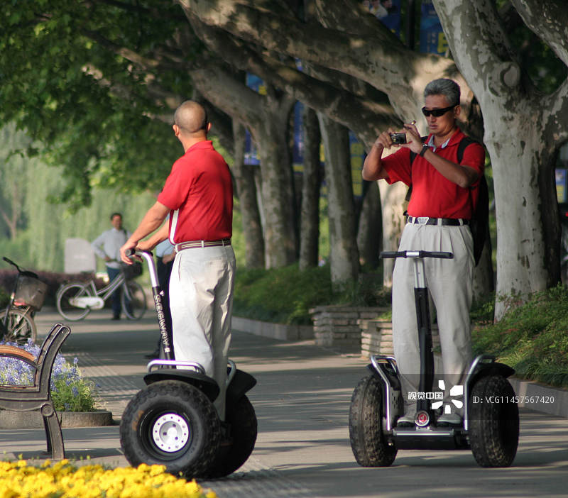 2009年5月8日，杭州，一名外国游客骑着思维车游览西湖。