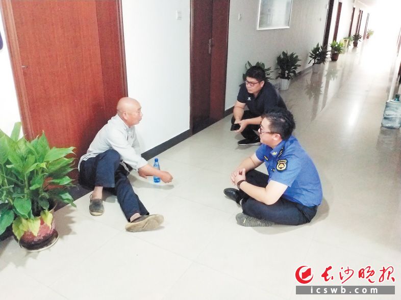 　　王磊坐在地上与老人耐心交流沟通。  受访者 供图