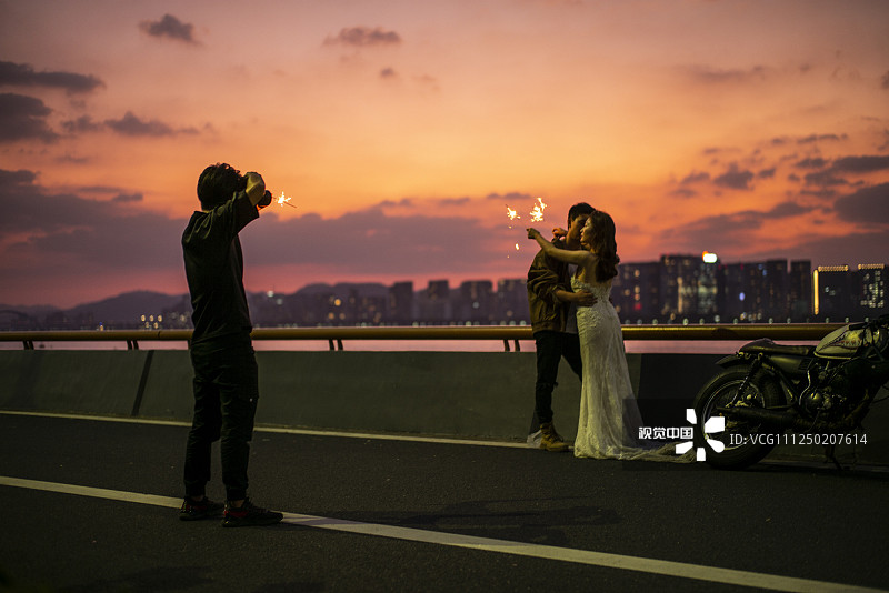 2019年9月19日傍晚，杭州钱塘南岸，一对对新人来到新城拍摄结婚照，还有在江边休息的人们。