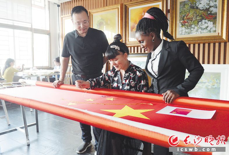 24日,一面宽1.9米、高1.28米的真丝面料湘绣国旗绣制完工。这面有着特殊意义的国旗将快递给远在非洲工作的王森波。长沙晚报全媒体记者 石祯专 摄