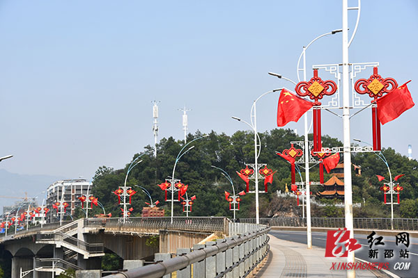 为热烈庆祝中华人民共和国成立70周年，近段时间，新邵县的大街小巷、商铺门店，乃至普通市民家，处处可见迎风招展的五星红旗。