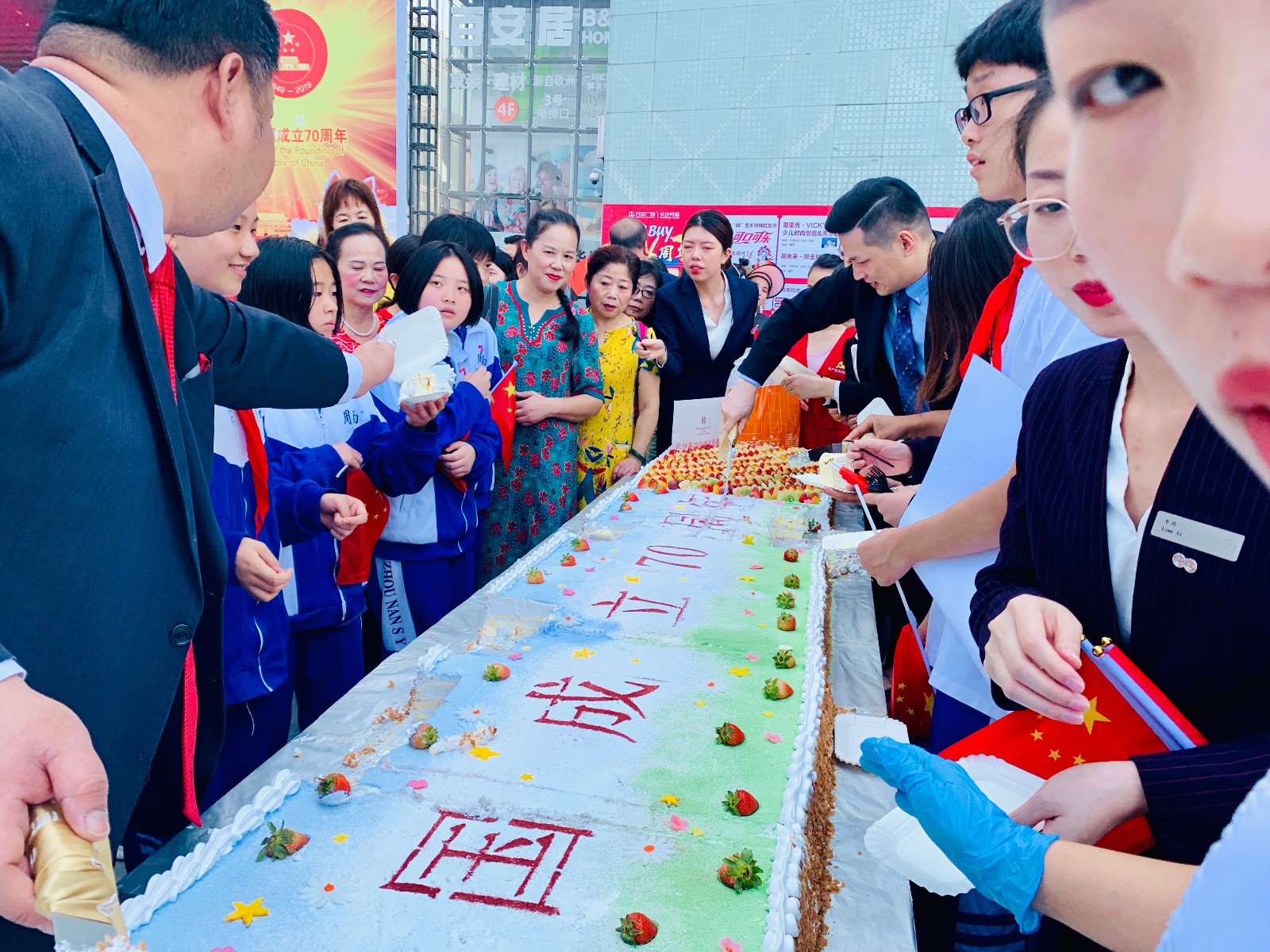 市民当街免费分享7米长的巨型生日蛋糕，一起为祖国庆生。 全媒体记者 李卓 摄