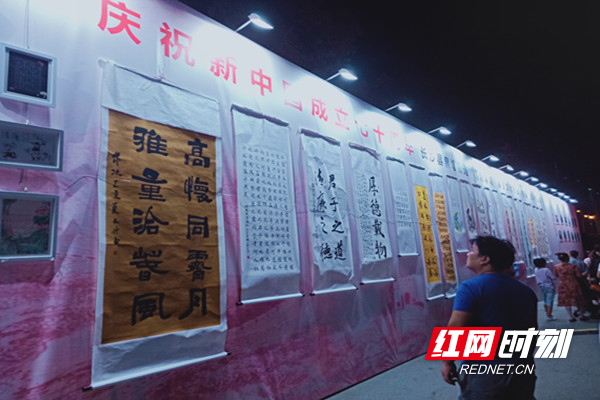 居民正在观看作品墙上书画、摄影等作品。.jpg 居民正在观看作品墙上书画、摄影等作品。.jpg