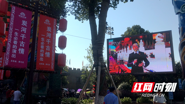 宁乡市炭河古城的电子大屏上，正播放着国庆阅兵庆典活动。