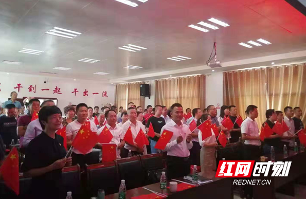 灰汤镇，党员干部和群众一起，挥舞着国旗，共看阅兵仪式。