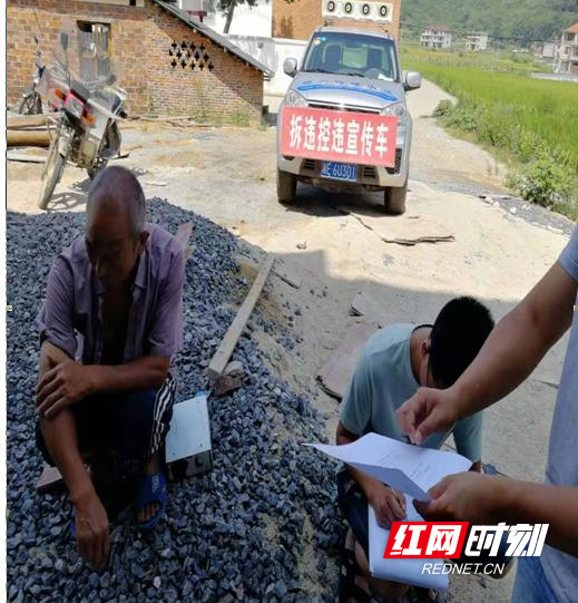 执法人员巡查发现违建现场下发停工通知书进行制止.jpg