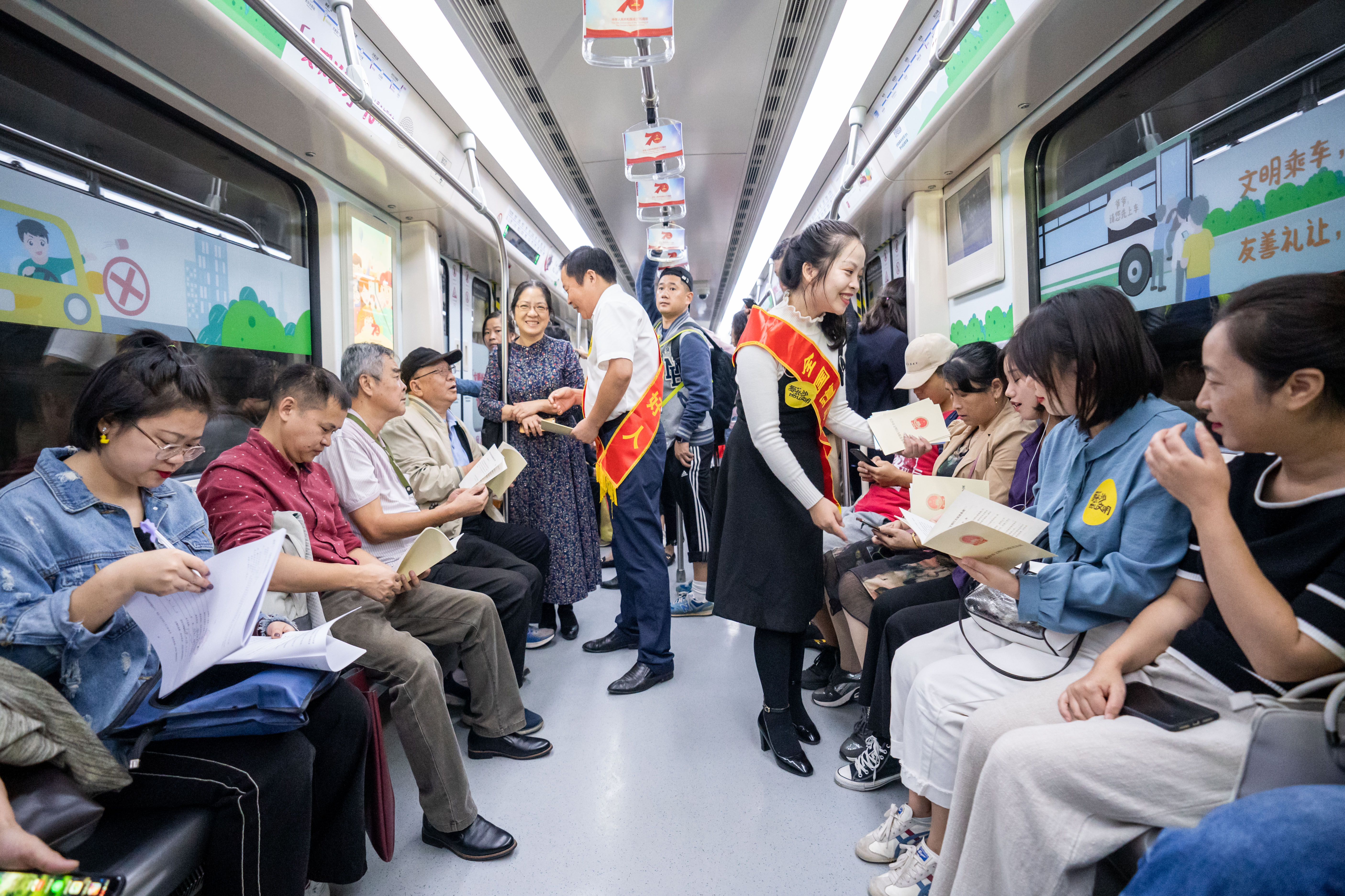 文明模范在“长沙文明号”地铁车厢内倡导文明行为规范。