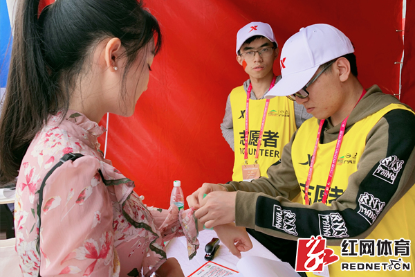 志愿者在为参赛者佩戴参赛手环。