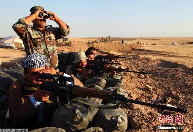 资料图:伊拉克库尔德战士与极端组织作战。