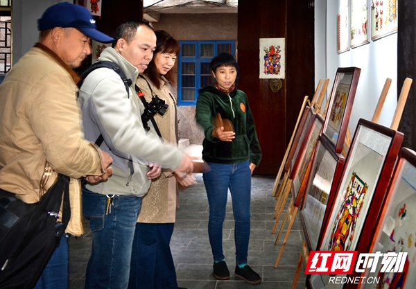 尹冬香在滩头年画展览室向来宾介绍滩头年画作内容。