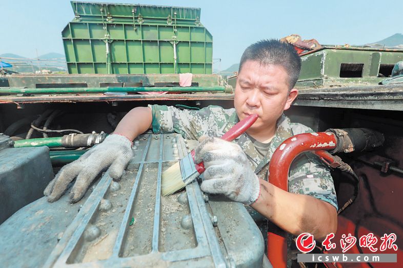 　　谭斌在对战车进行维护。 受访者供图