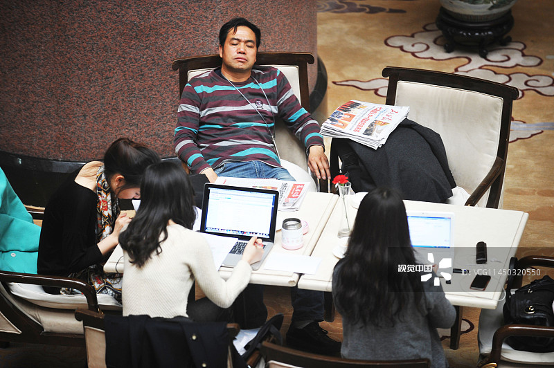 2013年3月6日，北京，全国两会期间，在一代表驻地的大厅里，记者们在咖啡厅工作，一位记者睡着了。